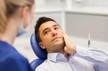 man holding jaw from TMJ pain | bruxism treatment arvada, co