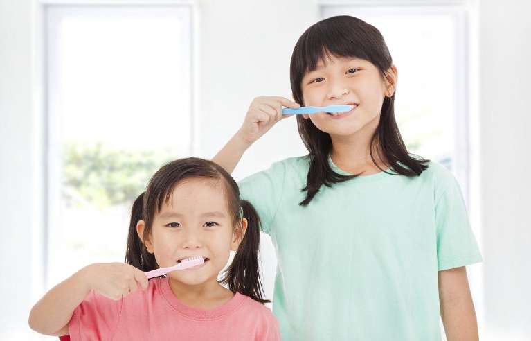 Children's dentist Arvada | girls brushing teeth