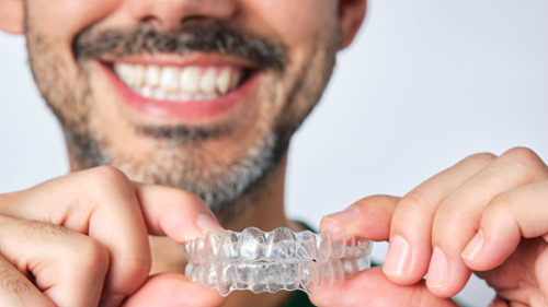 Man smiling with clear aligner in Arvada office